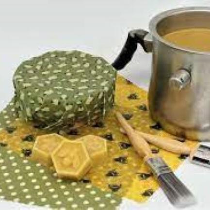 image of a wax melting pot, cotton cloth, a few cubes of beewswax, and a couple of paintbrushes