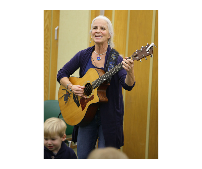 image of a woman holding a guitar and singing